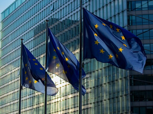 EU flags waving in front of the European Commission building in Brussels, Belgium.