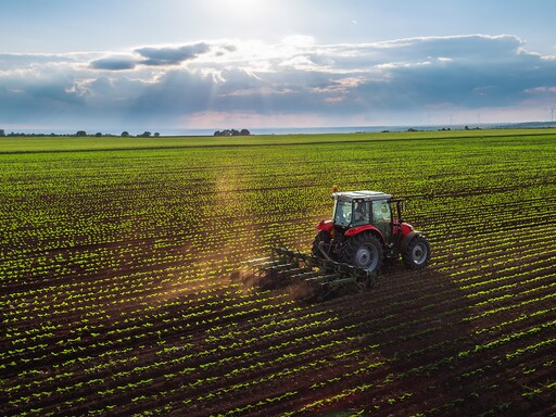 Tractor em trabalho num campo cultivado em perspectiva