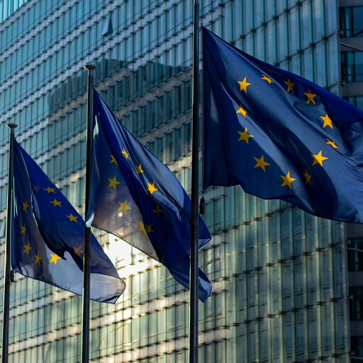 EU flags waving in front of the European Commission building in Brussels, Belgium.